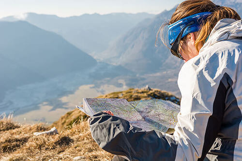 Woman looking at a printed map in nature.